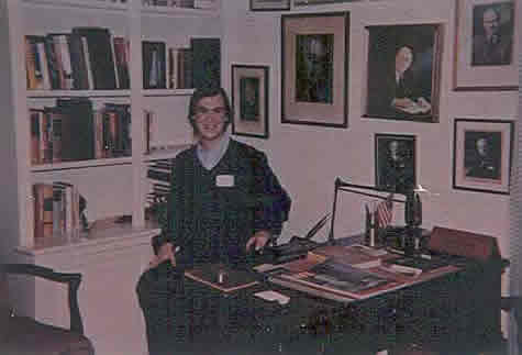 Neil sits at Mr. Byrnes' desk in the Byrnes home.